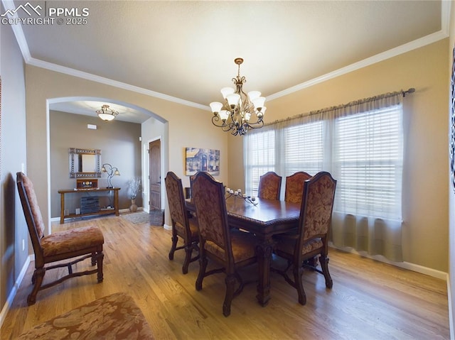 dining room with ornamental molding, a chandelier, and light hardwood / wood-style floors