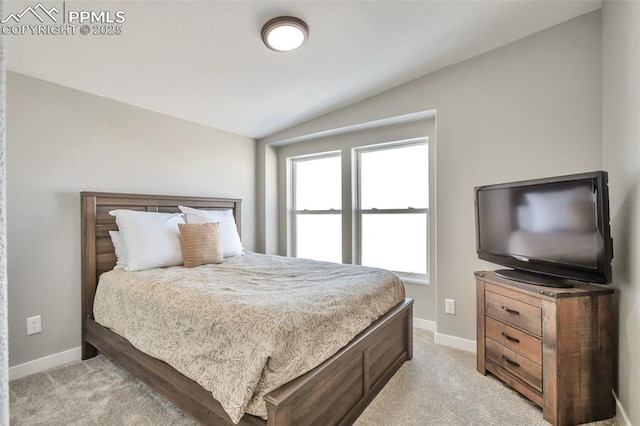 bedroom with vaulted ceiling, baseboards, and light colored carpet