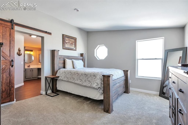 carpeted bedroom with connected bathroom, lofted ceiling, and a barn door