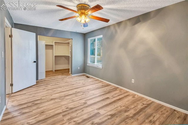 unfurnished bedroom featuring a closet, ceiling fan, light hardwood / wood-style floors, and a textured ceiling