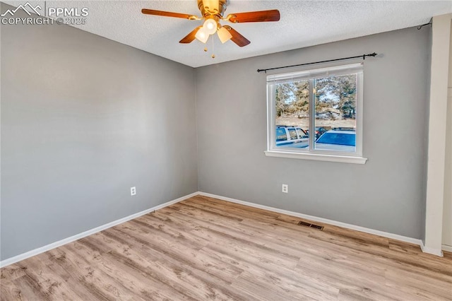 empty room with ceiling fan, a textured ceiling, and light hardwood / wood-style flooring