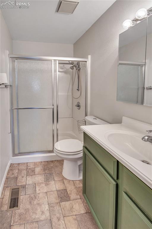 bathroom featuring vanity, toilet, and walk in shower