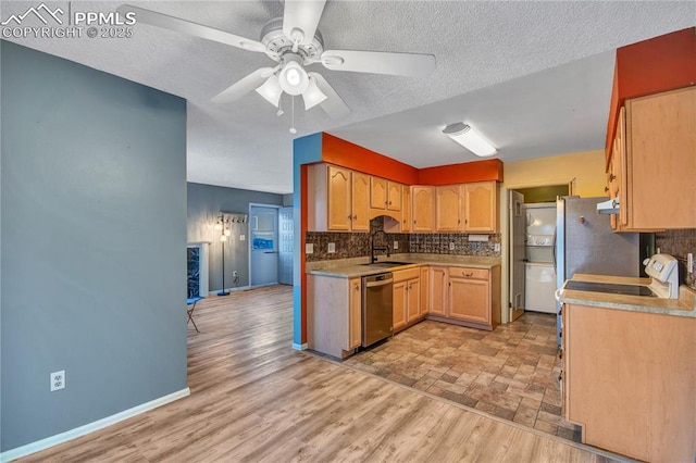 kitchen featuring ceiling fan, appliances with stainless steel finishes, sink, tasteful backsplash, and a textured ceiling