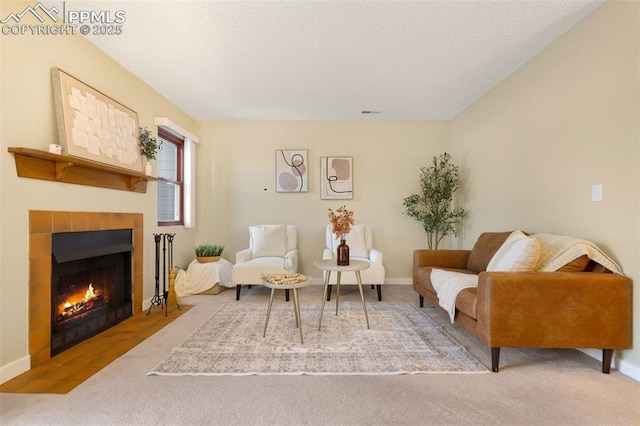 sitting room with a tile fireplace and carpet flooring