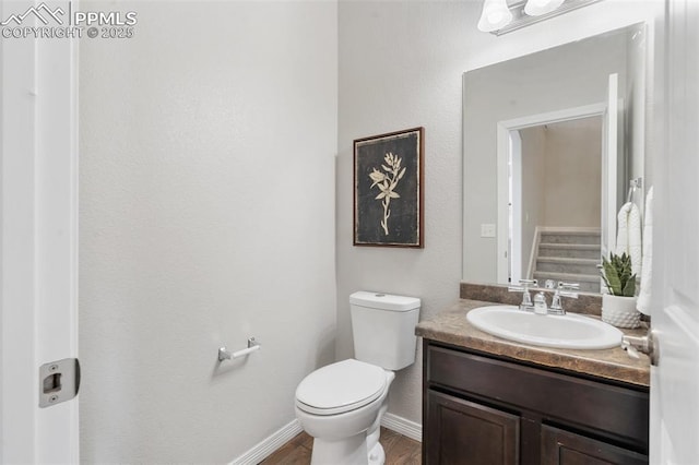 bathroom featuring hardwood / wood-style flooring, toilet, and vanity