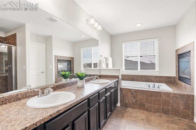 bathroom with vanity, independent shower and bath, and a tile fireplace