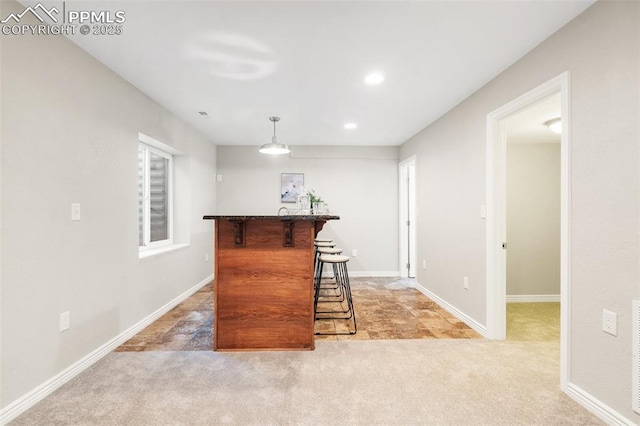 bar featuring decorative light fixtures and light carpet