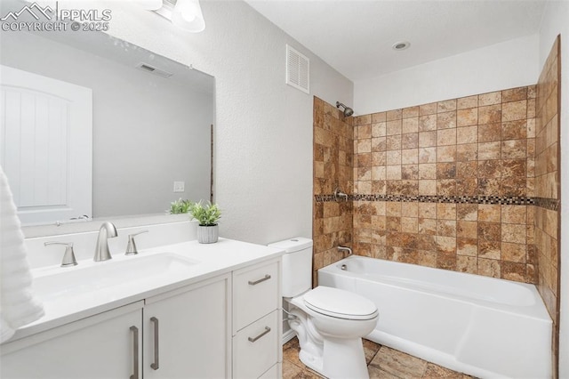 full bathroom featuring toilet, vanity, and tiled shower / bath