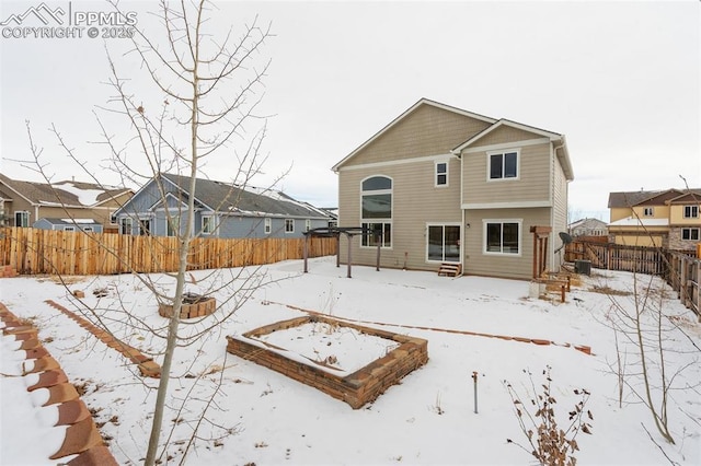 snow covered rear of property featuring central AC