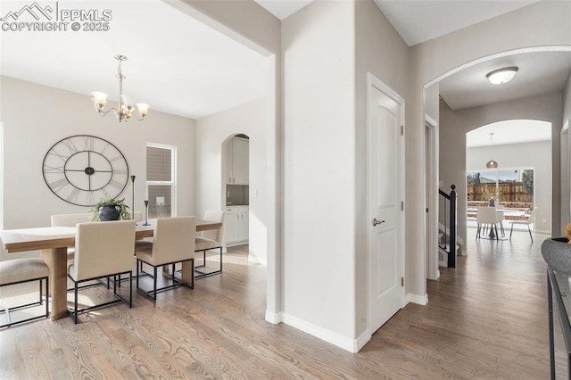 dining space featuring hardwood / wood-style flooring and an inviting chandelier