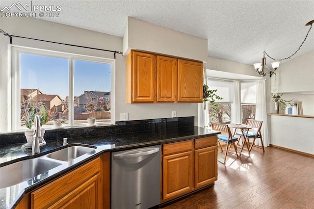 kitchen featuring stainless steel dishwasher, a wealth of natural light, sink, and a textured ceiling