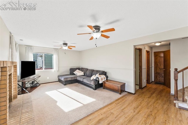 living room featuring a textured ceiling, ceiling fan, and hardwood / wood-style flooring