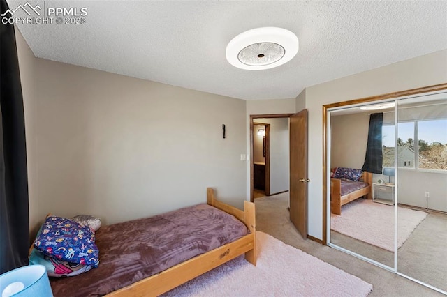 bedroom featuring a textured ceiling, a closet, and carpet flooring