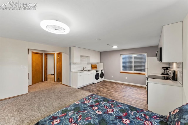 kitchen with white cabinetry, appliances with stainless steel finishes, decorative backsplash, washer / clothes dryer, and sink