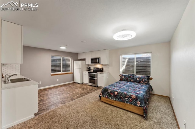 bedroom featuring carpet, sink, and white refrigerator