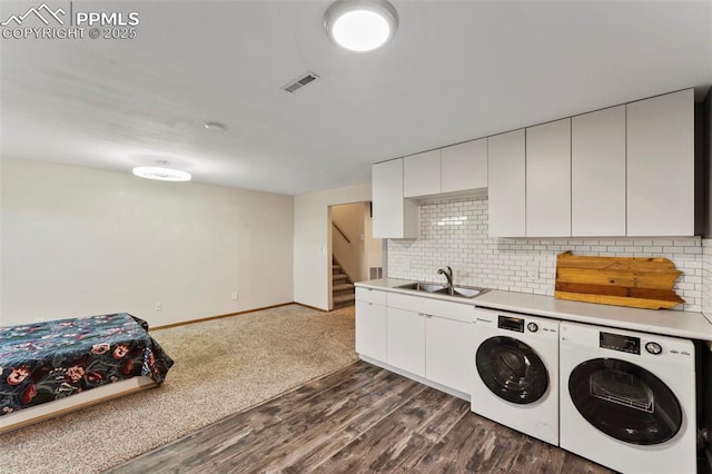 laundry area featuring dark hardwood / wood-style flooring, washer and clothes dryer, and sink