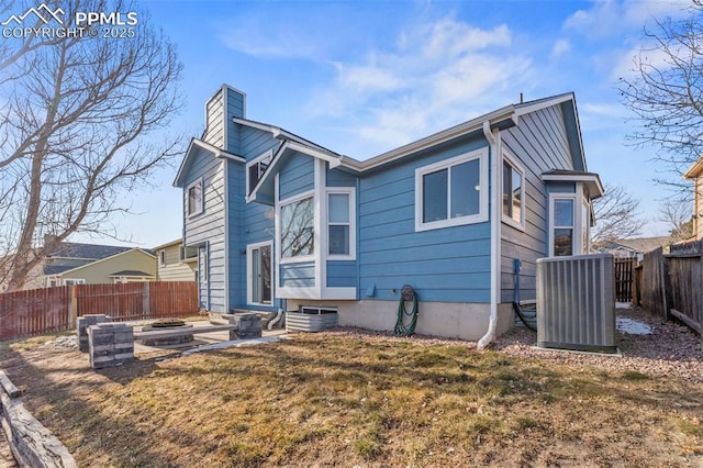 back of property featuring cooling unit and a yard