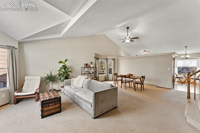 carpeted living room with ceiling fan with notable chandelier, a textured ceiling, and lofted ceiling