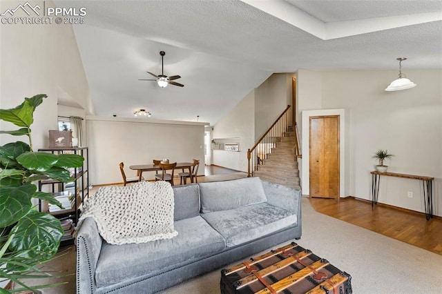 living room with lofted ceiling, ceiling fan, and dark colored carpet