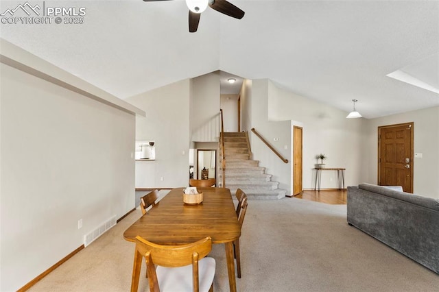 dining area featuring ceiling fan, lofted ceiling, and light colored carpet