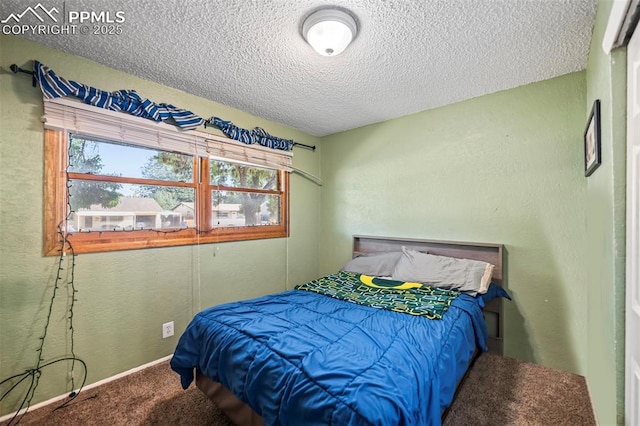 bedroom featuring a textured ceiling and carpet