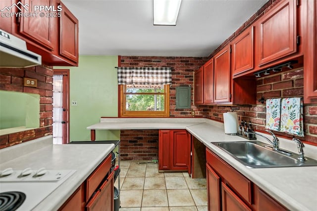 kitchen featuring sink, brick wall, light tile patterned floors, and extractor fan