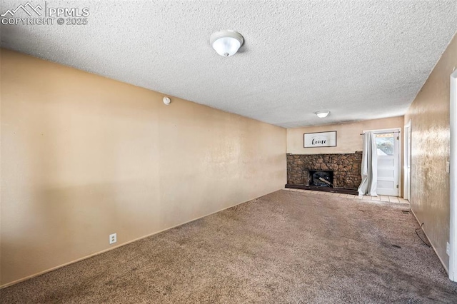 unfurnished living room with carpet, a textured ceiling, and a stone fireplace