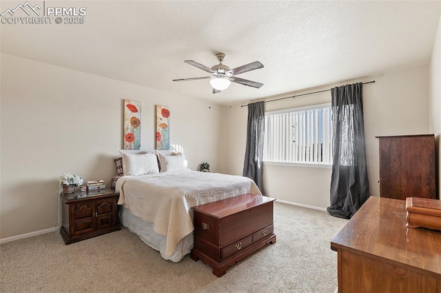 bedroom featuring light carpet, a ceiling fan, baseboards, and a textured ceiling