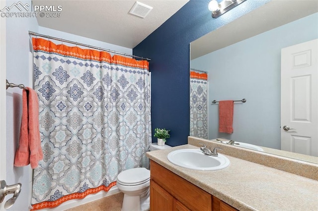 bathroom with visible vents, a shower with shower curtain, toilet, vanity, and tile patterned floors