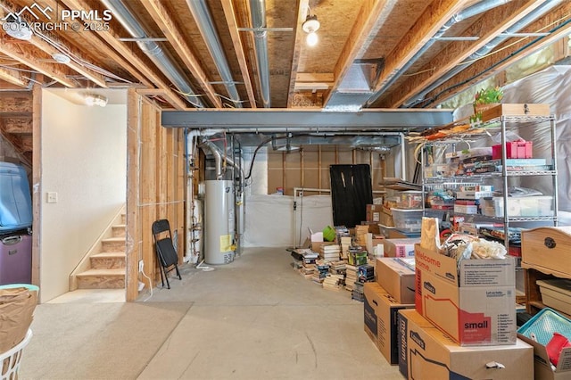 unfinished basement with gas water heater and stairway