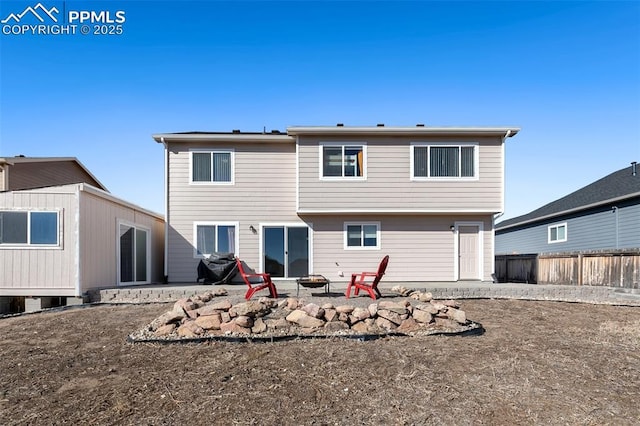 rear view of property with fence, a fire pit, and a patio