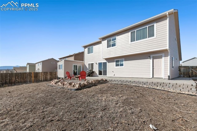 rear view of house featuring a fenced backyard and a patio