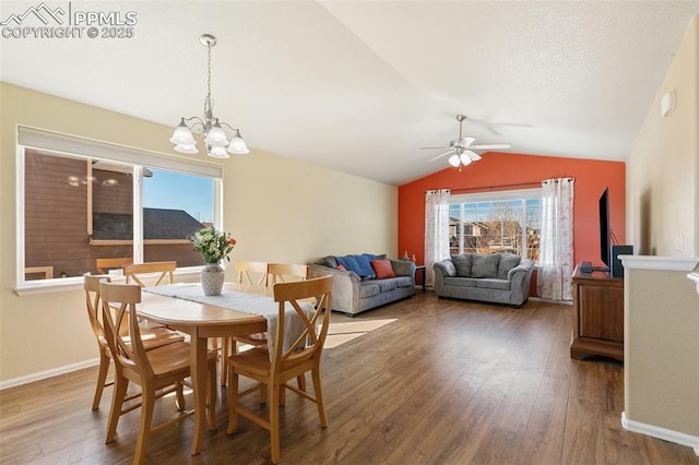 dining area with lofted ceiling, a textured ceiling, ceiling fan with notable chandelier, wood finished floors, and baseboards