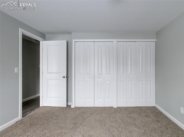 unfurnished bedroom featuring carpet floors and two closets