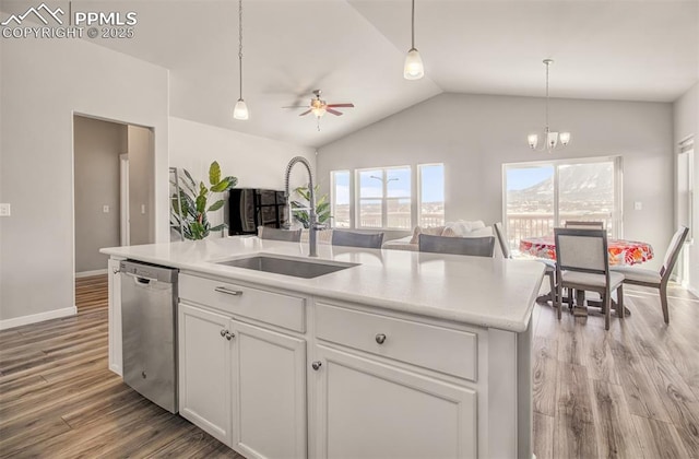 kitchen with lofted ceiling, sink, white cabinetry, dishwasher, and a kitchen island with sink