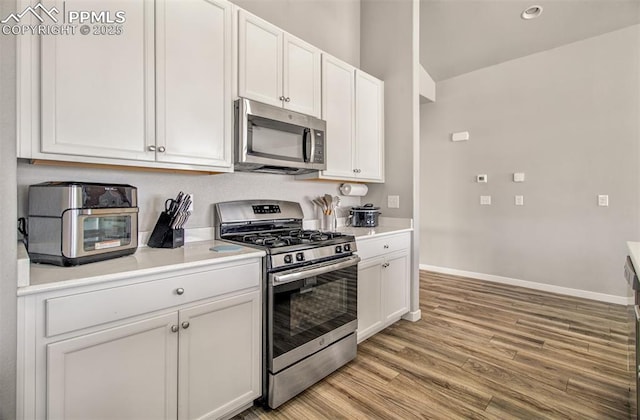 kitchen featuring white cabinetry, light hardwood / wood-style floors, and appliances with stainless steel finishes