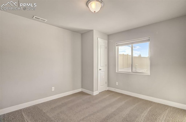 spare room featuring light colored carpet