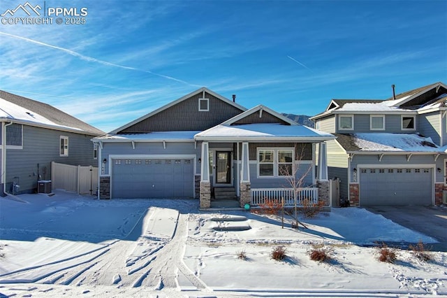 view of front of home with central AC unit, a garage, and covered porch