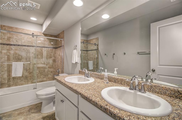 full bathroom with toilet, vanity, and bath / shower combo with glass door