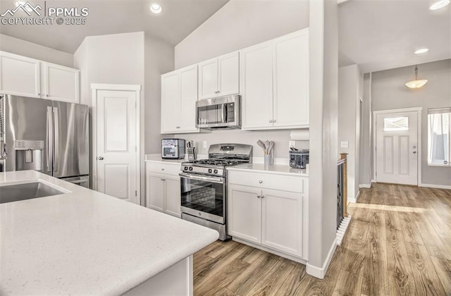 kitchen with white cabinetry, appliances with stainless steel finishes, and light wood-type flooring