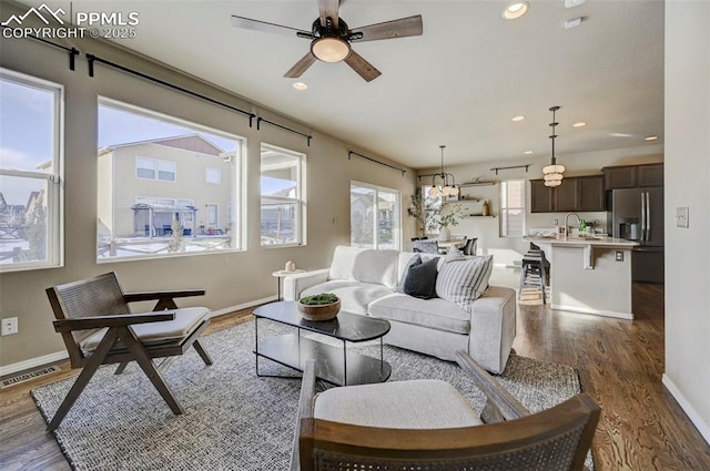 living room with sink, dark hardwood / wood-style floors, and ceiling fan