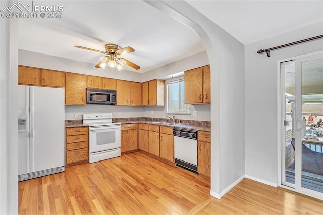 kitchen featuring sink, white appliances, light hardwood / wood-style flooring, and ceiling fan