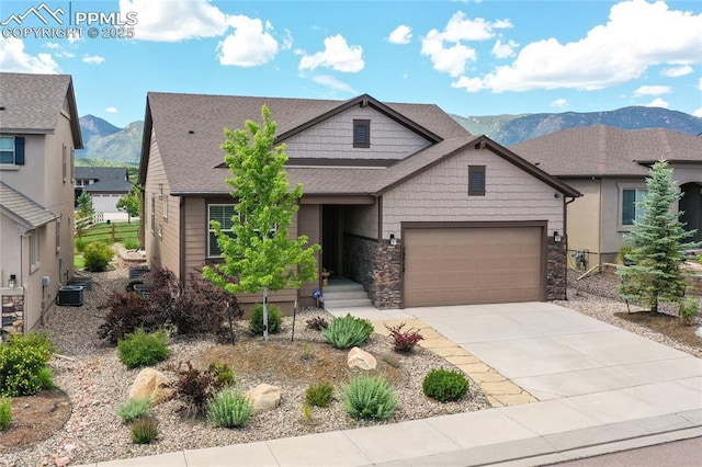 view of front of house with a garage, central AC, and a mountain view