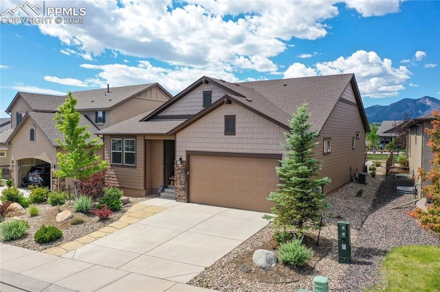 view of front of property featuring central AC unit, a mountain view, and a garage