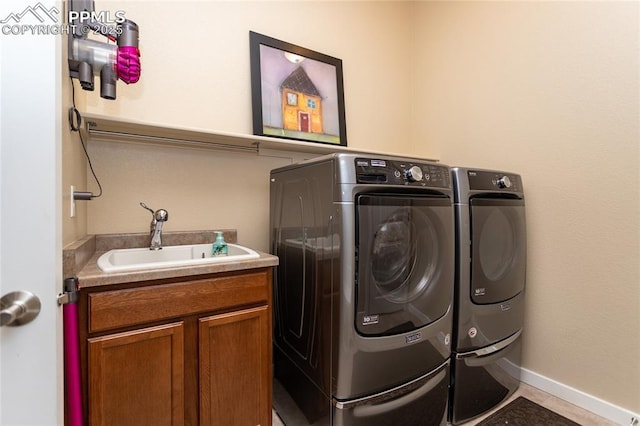 laundry area with washer and dryer, sink, and cabinets