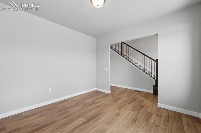16896 Greenfield Dr, Monument, CO 80132 - unfurnished room with baseboards, stairway, and light wood-style floors