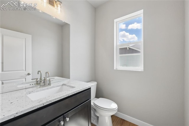 16896 Greenfield Dr, Monument, CO 80132 - half bathroom featuring toilet, wood finished floors, vanity, and baseboards