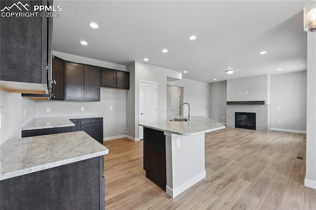 16896 Greenfield Dr, Monument, CO 80132 - kitchen featuring light wood-type flooring, a sink, dark brown cabinets, and baseboards