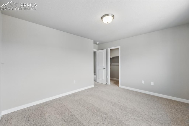 16896 Greenfield Dr, Monument, CO 80132 - unfurnished bedroom with carpet, a walk in closet, and baseboards