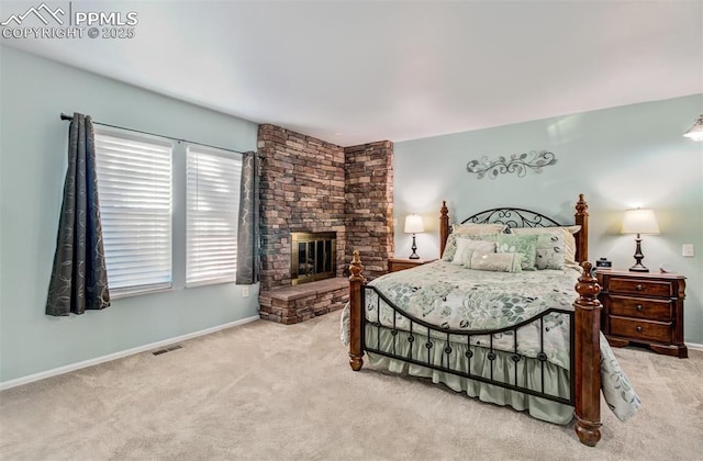 bedroom featuring a stone fireplace and carpet floors